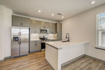 A kitchen with stainless steel appliances and a white counter top